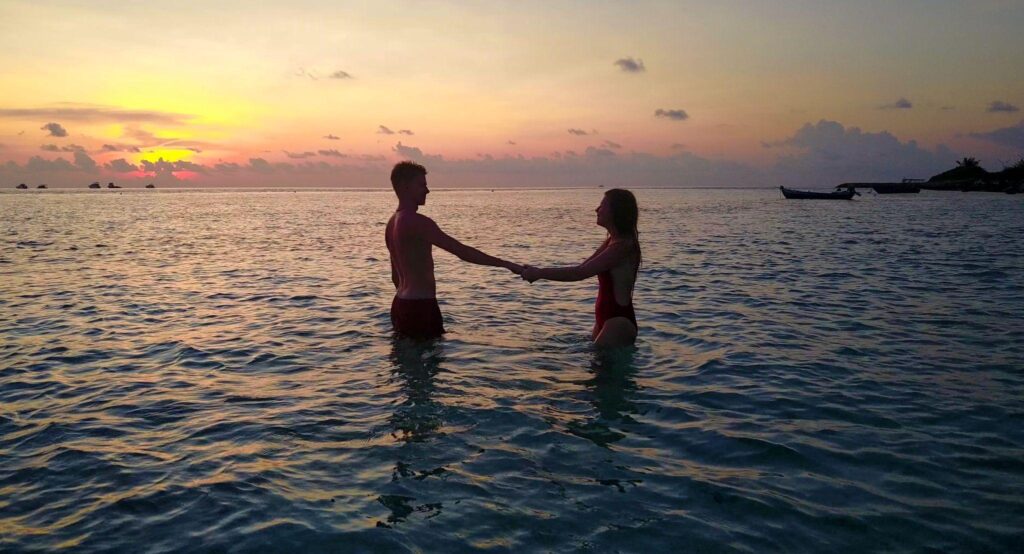 Couple enjoying luxury overwater villa in Maldives for romantic beach honeymoon trip